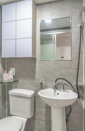 Un baño con inodoro, lavamanos y ducha.