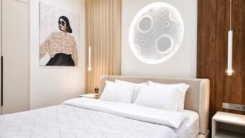 A modern bedroom with a geometric-patterned bedspread, a wall-mounted artwork, a moon-shaped light fixture, and a wooden panel accent.