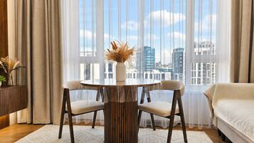Une chambre à coucher moderne avec une grande fenêtre, une table à manger ronde et un lit.