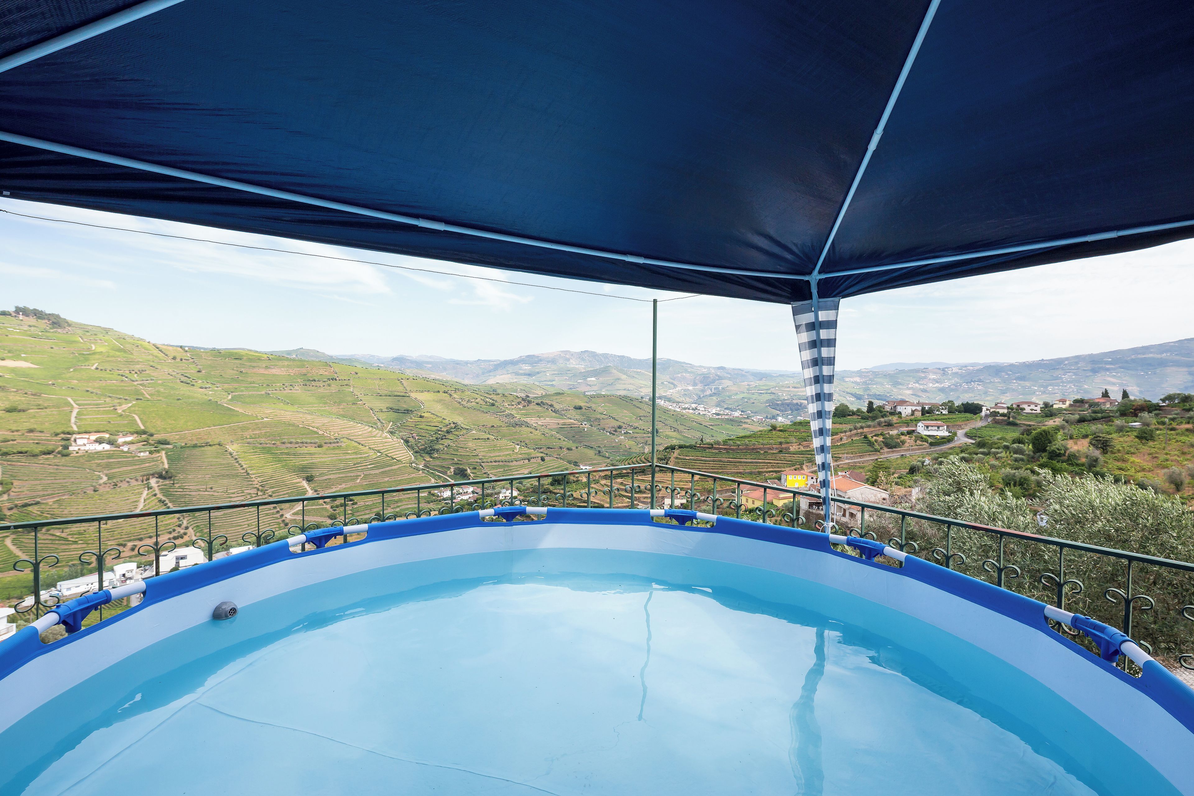 A pool with a view of terraced fields and distant hills.
