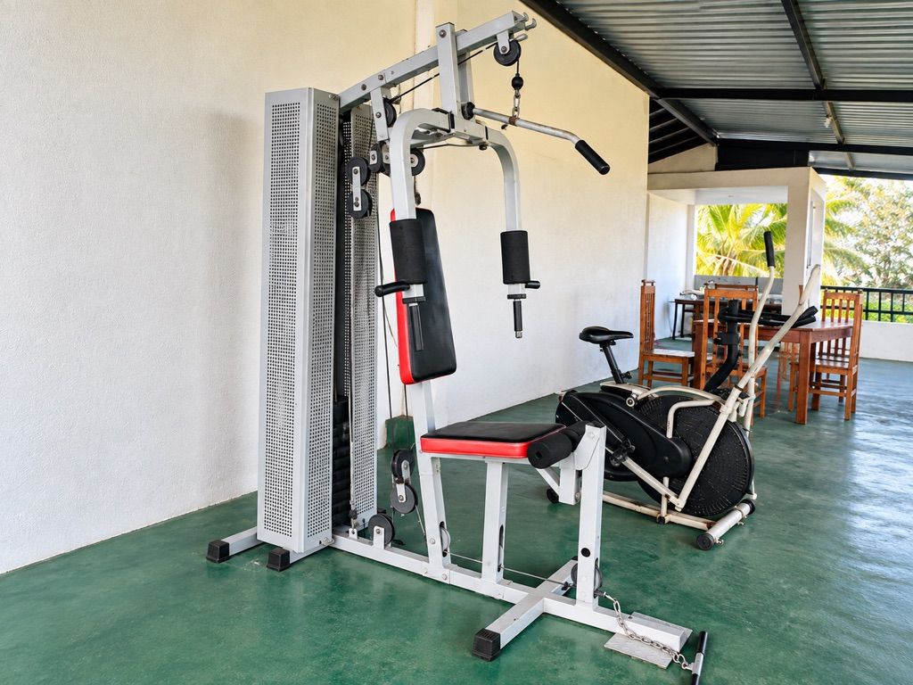 A gym with a weight machine, a bench, and a treadmill.