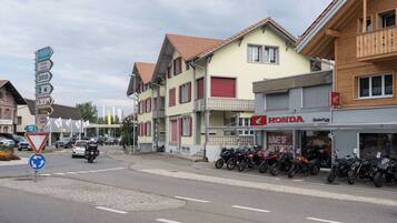 Eine Straße mit Gebäuden, einem Honda-Motorradgeschäft und einem Kreisverkehrschild.