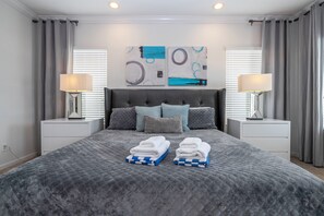 Quarto moderno com uma cama grande, duas mesas de cabeceira e uma cabeceira.