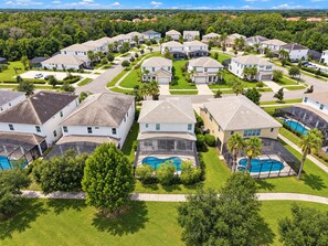 A residential area with houses, swimming pools, and a clear sky. - Bella Vida 5BR Pool Home with Game Room & Loft (Kissimmee)