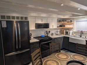 A modern kitchen with stainless steel appliances, a microwave, and a gas stove. - NEW!  The Deer and Birches Combination - 2 Beautiful Houses on the Same Property! (Frankfort)