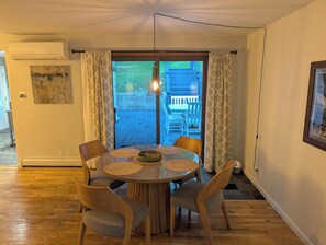 Un comedor con una mesa redonda, cuatro sillas y vistas a una terraza exterior.
