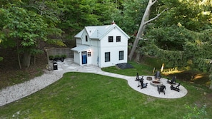 A two-story white house with a front porch, a fire pit, and outdoor seating. - NEW!  The Deer and Birches Combination - 2 Beautiful Houses on the Same Property! (Frankfort)