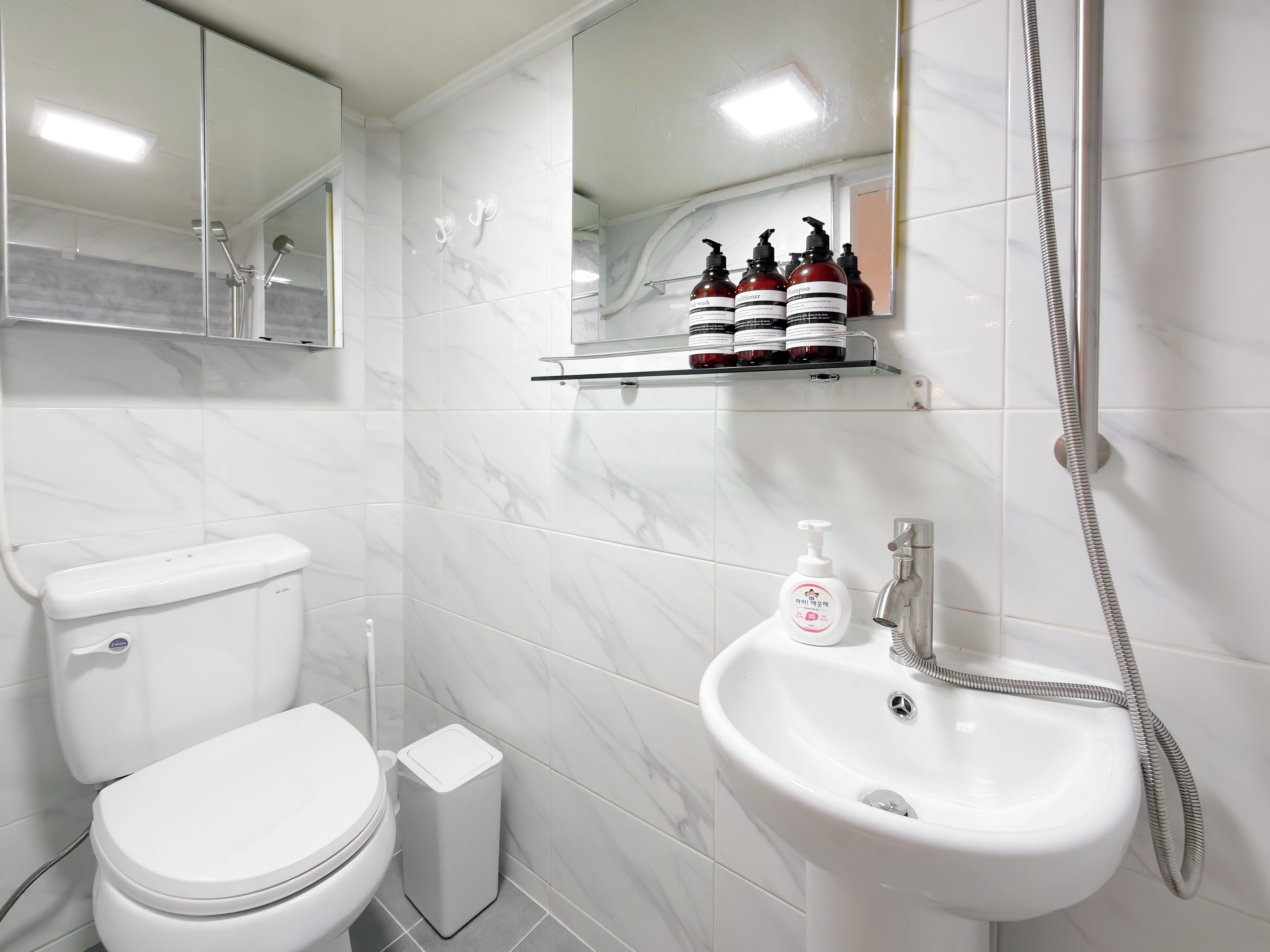 A bathroom with a toilet, a sink, and a shower.