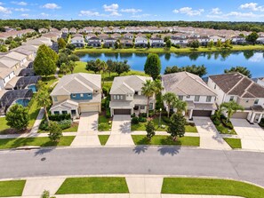 A residential area with houses, a lake, and a clear sky. - Near Disney Private Pool Bella Vida Resort (Kissimmee)