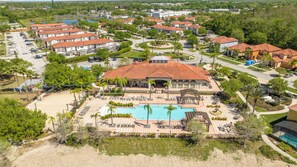 An aerial view of a resort with a central pool, multiple buildings with red roofs, and surrounding greenery. - Near Disney Private Pool Bella Vida Resort (Kissimmee)