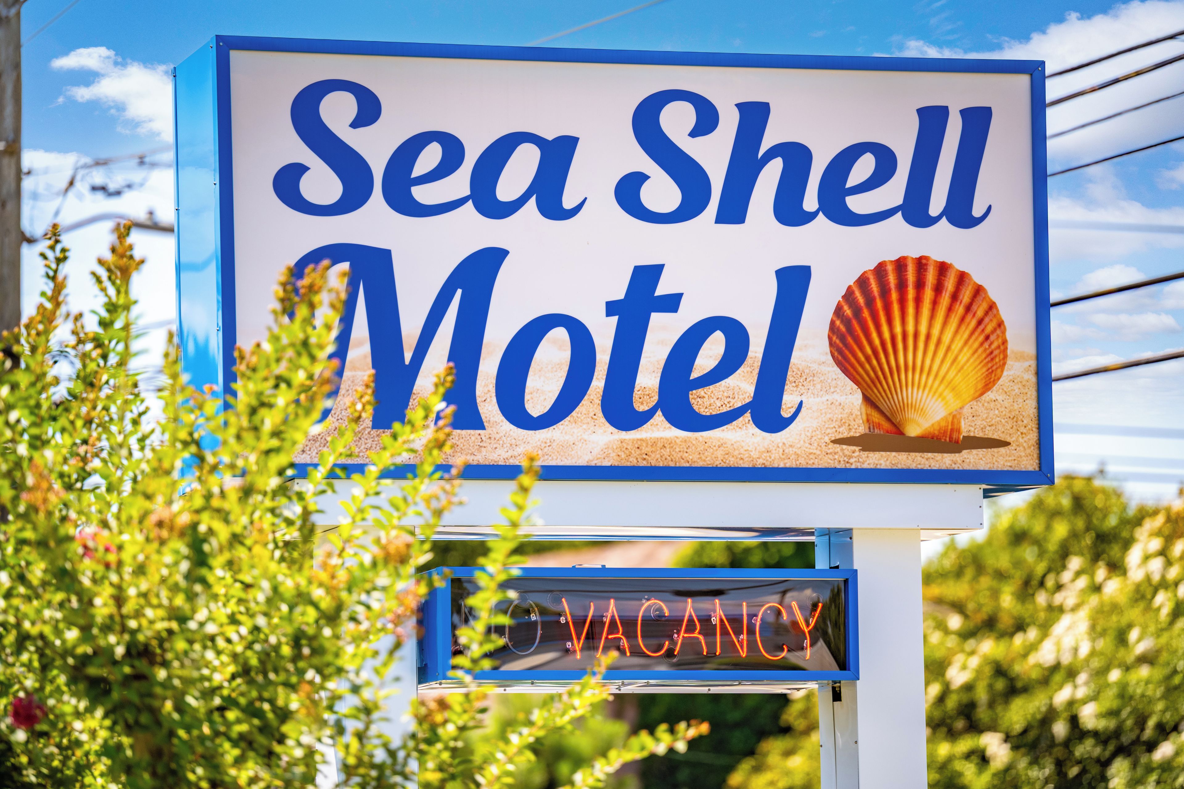 A motel sign with the name 'Sea Shell Motel' and a seashell graphic.