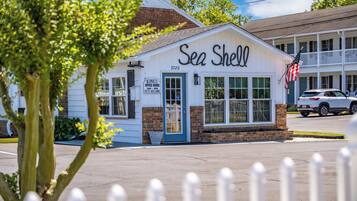 A white building with a sign reading 'Sea Shell' and a small American flag.