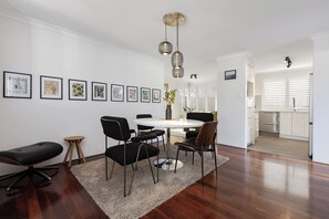 Un comedor moderno con una mesa redonda, sillas negras y un tapete decorativo.