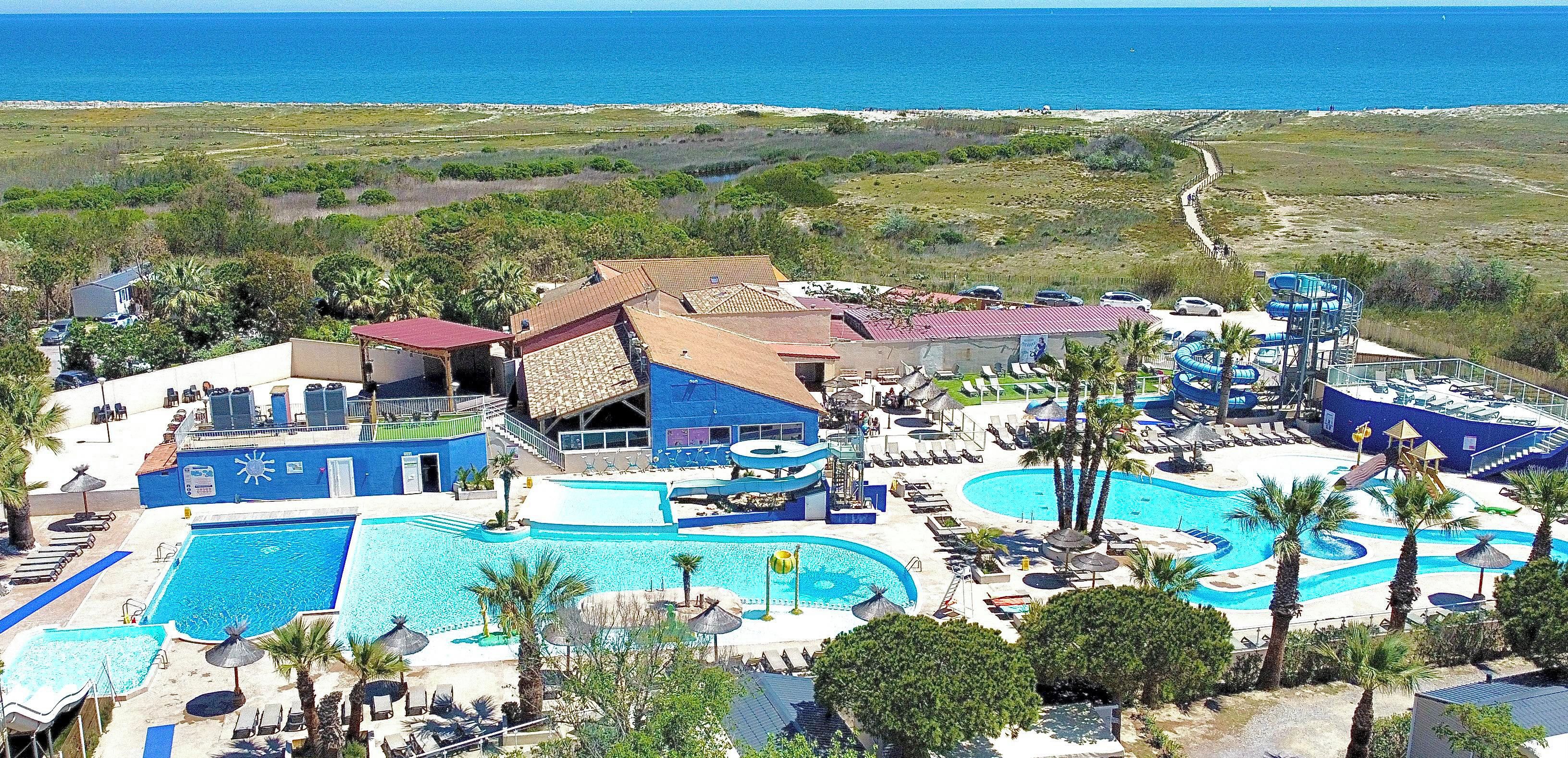 Een resort met meerdere zwembaden, een waterpark en een strandgedeelte.