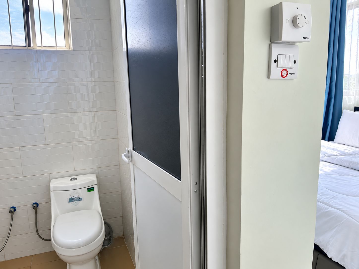 Un baño con inodoro, ducha y ventana.
