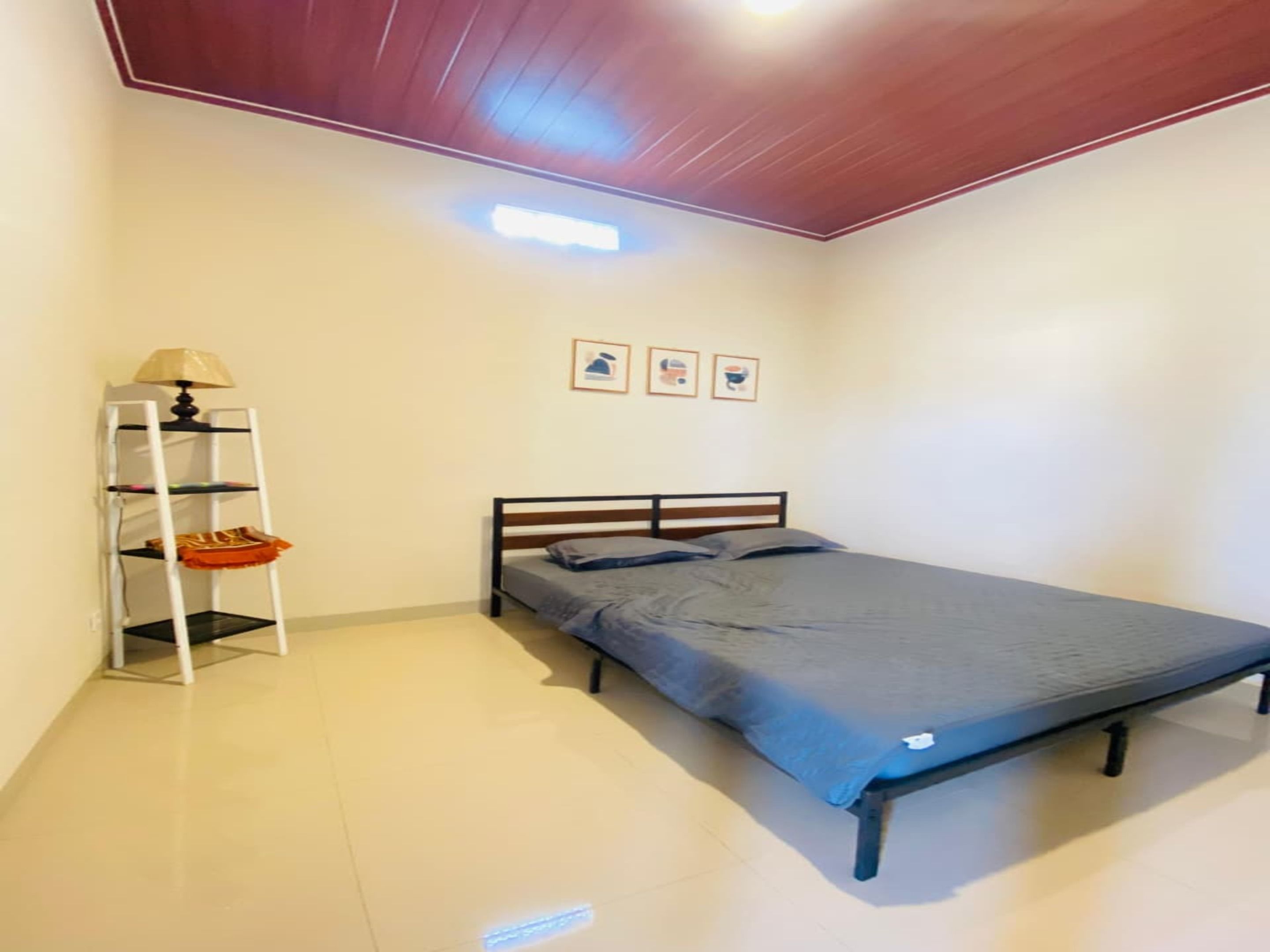 Ein Schlafzimmer mit einem Einzelbett, einer weißen Regalwand und einer Lampe.