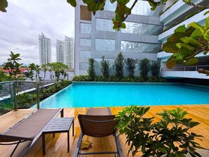 A rooftop swimming pool with lounge chairs and a view of high-rise buildings. - Neu suite Standard Room By Rasbo Galaxy (Kuala Lumpur)