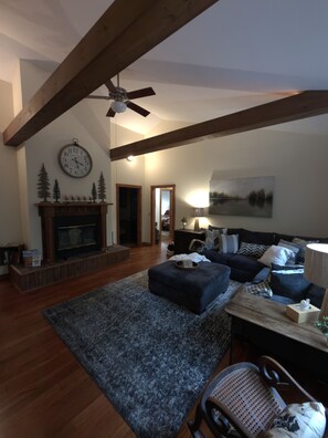 Una sala de estar con chimenea, ventilador de techo y sofá.