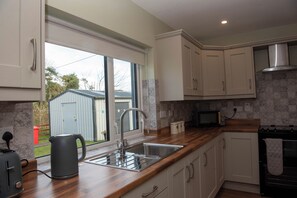 A modern kitchen with a large window, stainless steel appliances, and wooden countertops. - entire 3 bed home on the outskirts of Donegal Town (Donegal Town)