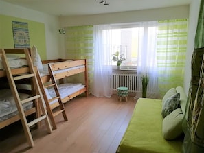 A room with bunk beds, a small stool, a radiator, and a window with curtains. - Vacation Rental with an Extra-Large Natural Garden & Sunny Terrace (Clausthal-Zellerfeld)