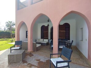 A covered outdoor seating area with multiple arches, cushioned seating, and a tiled floor. - STUNNING VILLA - 4 BEDROOMS - PRIVATE POOL - QUIET LOCATION (Unknown)