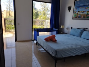 A hotel room with a bed, a desk, a balcony, and a painting on the wall. - STUNNING VILLA - 4 BEDROOMS - PRIVATE POOL - QUIET LOCATION (Unknown)