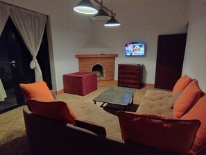 A living room with a fireplace, a television, and a sofa set. - STUNNING VILLA - 4 BEDROOMS - PRIVATE POOL - QUIET LOCATION (Unknown)