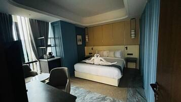 A hotel room with a bed, a desk, and a chair.