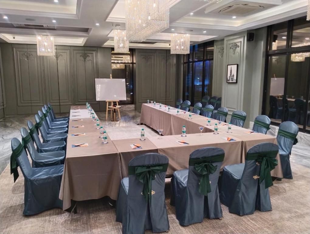 Un salón de conferencias con una larga mesa, sillas y una pizarra.