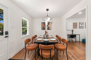 A dining area with a rectangular table, eight chairs, and a pendant light. - Movie Theatre Southpark Patio WFH Setup (Charlotte)