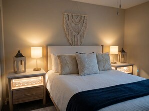 Ein Schlafzimmer mit einem Bett, zwei Nachttischen und einer Wanddekoration aus Makramee.