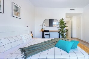 A modern bedroom with a bed, a desk, and a mirror. - Playa Negra 1 - Two Bed Townhouse (Puerto Santiago)