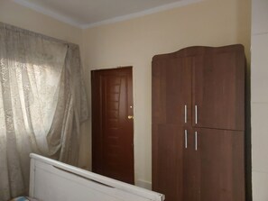 A bedroom with a bed, a wardrobe, and a door. - Number Pyramids (Cairo)