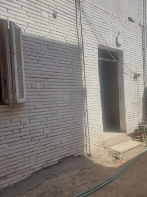 A brick building with a window and an open doorway. - Number Pyramids (Cairo)