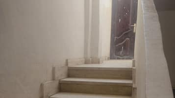 A staircase leading to a dark wooden door.