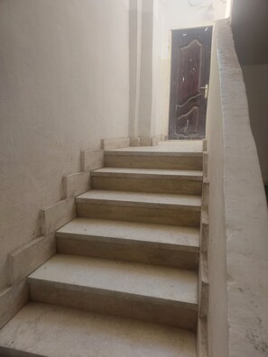 A staircase leading to a dark wooden door. - Number Pyramids (Cairo)