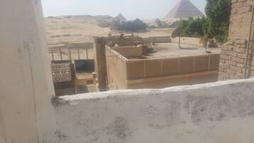 Vista de las Pirámides de Giza desde un balcón de hotel, con cielo despejado.