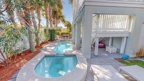 A swimming pool with a sun deck, surrounded by palm trees and a covered seating area. - Punta Vista Mare 4 Bedroom Home (Destin)