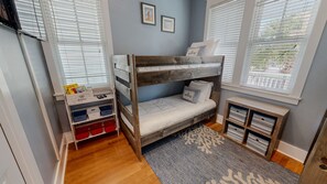 A bunk bed with a storage unit beside it, a small table with books, and a window with blinds. - Punta Vista Mare 4 Bedroom Home (Destin)