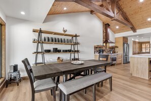 A modern kitchen with wooden beams, a central island, and built-in appliances. - Guadalupe Bluff Trail House 5 Bedroom Home (Kerrville)