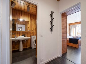 A modern bathroom with a wooden ceiling, a sink, a mirror, and a washing machine. - Bright central apartment - 4 guests (Val-d'Isère)