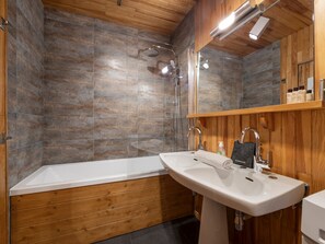 A modern bathroom with a wooden vanity, a white sink, and a glass shower enclosure. - Bright central apartment - 4 guests (Val-d'Isère)