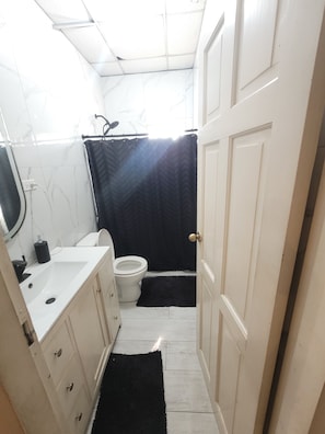 Ein schmales Badezimmer mit Toilette, Waschbecken und Schrank.