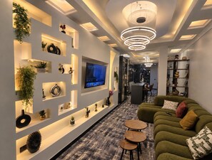 A modern living room with a flat-screen TV, a sofa, and a coffee table.
