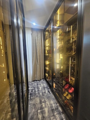 A walk-in closet with a mirrored wardrobe and a patterned floor. - SWIPE Villas (Kigali)