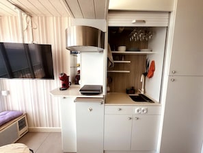 A compact kitchenette with a stove, microwave, and sink. - Charming studio, spectacular sea view - 4 guests (Platja d'Aro)