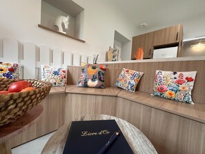 Una cocina moderna con una banca integrada, una cesta de fruta y almohadones decorativos.