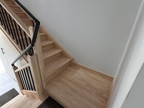 A wooden staircase with a black handrail leading to a landing. - Independent house, pets welcome - 8 guests (La Celle)
