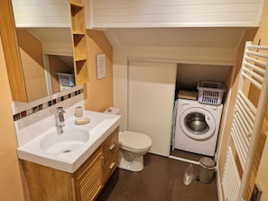 A compact bathroom with a sink, toilet, and built-in washing machine. - Cozy apartment with mountain views - 6 guests (Saint-Gervais-les-Bains)