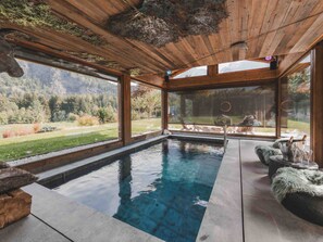 A modern indoor pool with wooden ceiling and large windows offering a view of the outdoors. - Chalet with pool, pets welcome, Mont Blanc view - 11 guests (Les Houches)